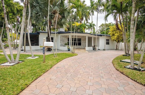 South Lake Villa | Modern Hollywood Beach villa with a private heated saltwater pool, hot tub, and spacious family-friendly layout. Just 1 mile from the ocean & Broadwalk, featuring a full kitchen, open living areas, and tropical outdoor lounge spaces.