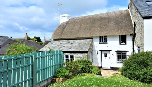 Charming Listed Thatched Cottage with parking and short walk to sandy beach .